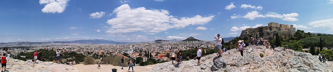 Athens spreading toward the Acropolis under a warm sky